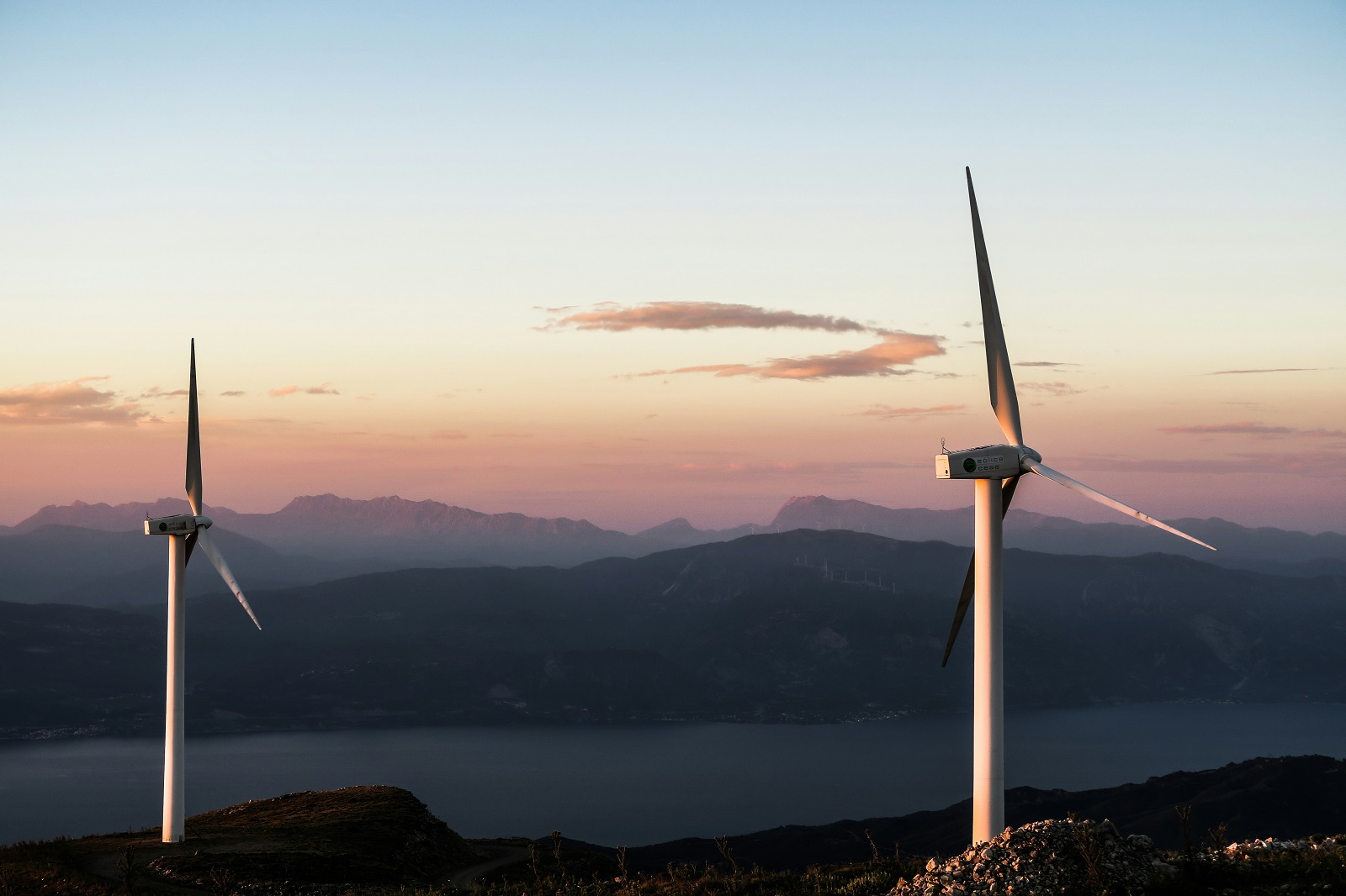 Elektrownie wiatrowe na tle gór i rzeki